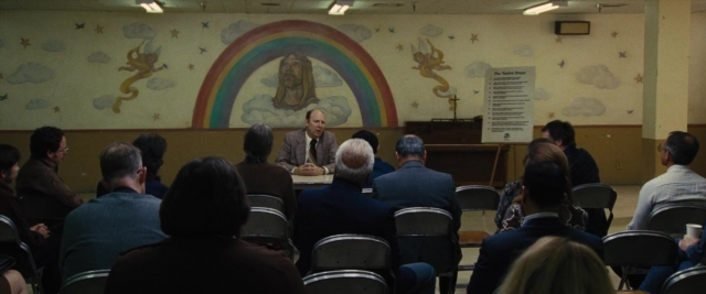 Wide shot frame from Battle of the Sexes — sitting, room, dialogue