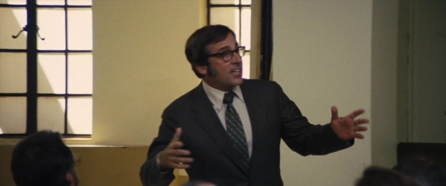Frame from Battle of the Sexes — sitting, standing, room