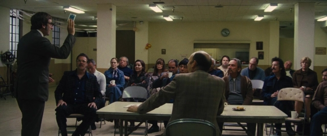 Wide shot frame from Battle of the Sexes — sitting, standing, plate
