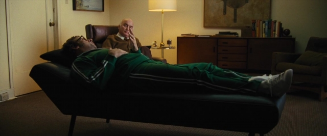 Frame from Battle of the Sexes — sitting, desk, book