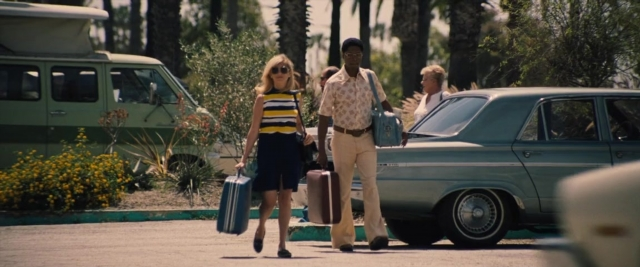 Medium shot frame from Battle of the Sexes — walking, street, car