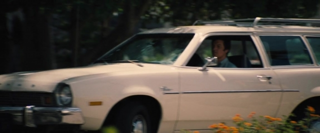 Wide shot frame from Battle of the Sexes — sitting, street, car