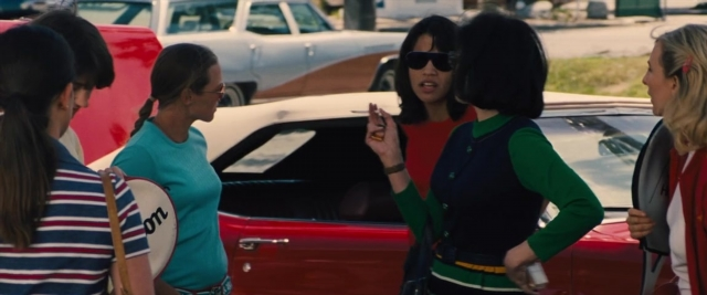 Wide shot frame from Battle of the Sexes — standing, dialogue, phone