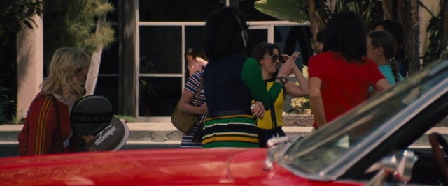 Wide shot frame from Battle of the Sexes — standing, street, car