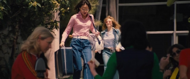 Wide shot frame from Battle of the Sexes — walking, phone, street
