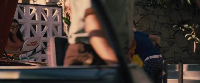 Wide shot frame from Battle of the Sexes — sitting, standing, table