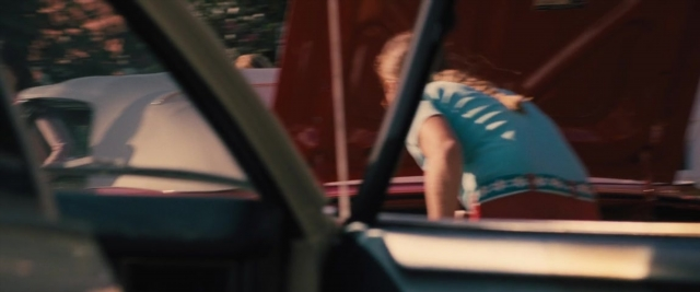 Wide shot frame from Battle of the Sexes — sitting, street, car