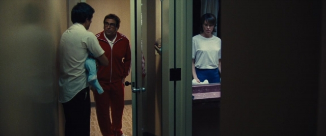Wide shot frame from Battle of the Sexes — standing, door, mirror