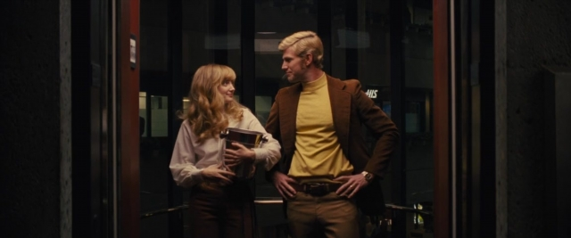 Wide shot frame from Battle of the Sexes — book, standing, dialogue