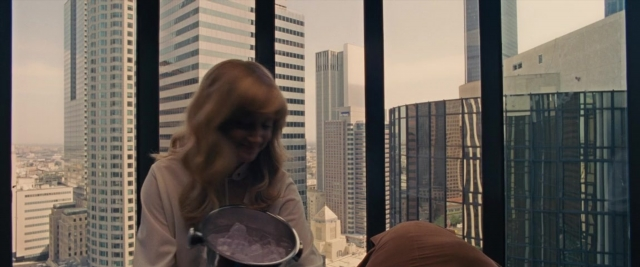 Wide shot frame from Battle of the Sexes — standing, glass, skyscraper
