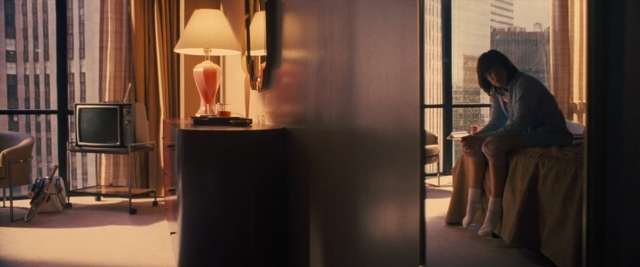 Wide shot frame from Battle of the Sexes — sitting, room, bed