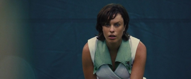 Wide shot frame from Battle of the Sexes — sitting, dress, chair