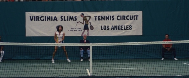 Frame from Battle of the Sexes — sitting, standing, suit