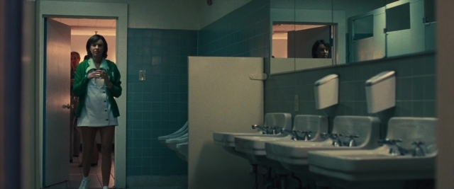 Wide shot frame from Battle of the Sexes — standing, phone, door