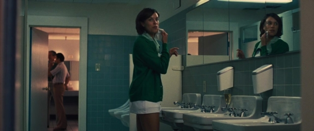 Wide shot frame from Battle of the Sexes — standing, mirror, hand