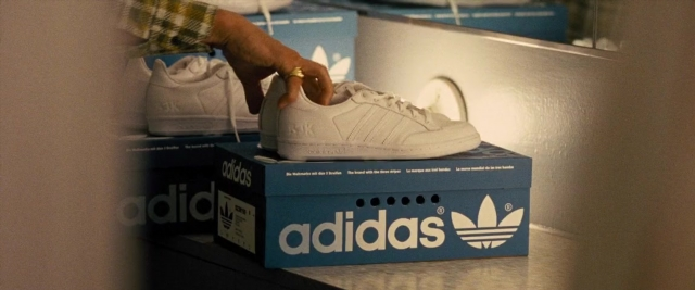 Frame from Battle of the Sexes — hand, shirt, box