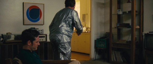 Frame from Battle of the Sexes — sitting, standing, room