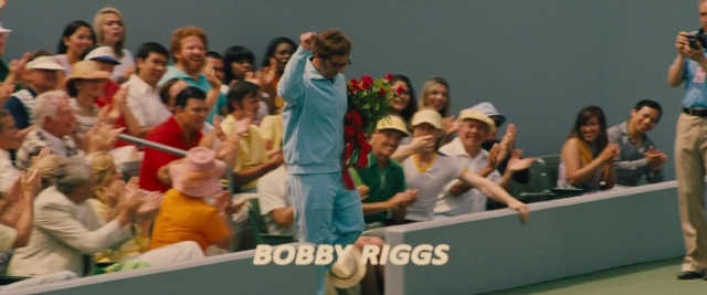 Wide shot frame from Battle of the Sexes — standing, hat, hand