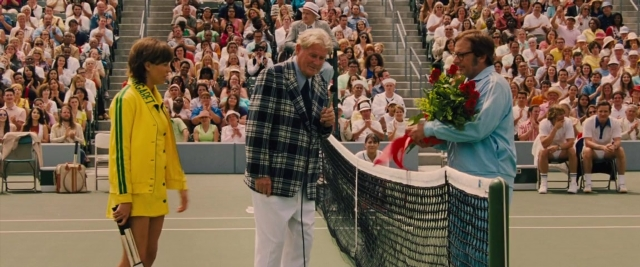 Wide shot frame from Battle of the Sexes — sitting, standing, dress