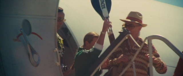 Frame from Battle of the Sexes — standing, hat, shirt