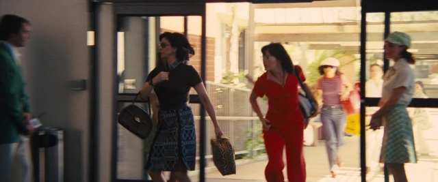 Wide shot frame from Battle of the Sexes — walking, door, hat