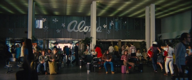 Wide shot frame from Battle of the Sexes — sitting, standing, person