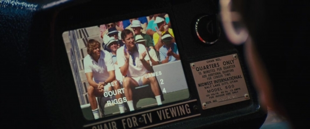 Wide shot frame from Battle of the Sexes — phone, car, face