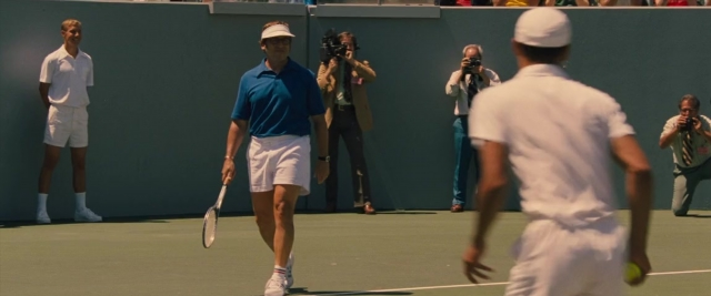 Wide shot frame from Battle of the Sexes — hat, shirt, camera