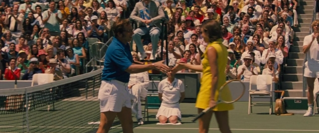 Wide shot frame from Battle of the Sexes — sitting, standing, dress