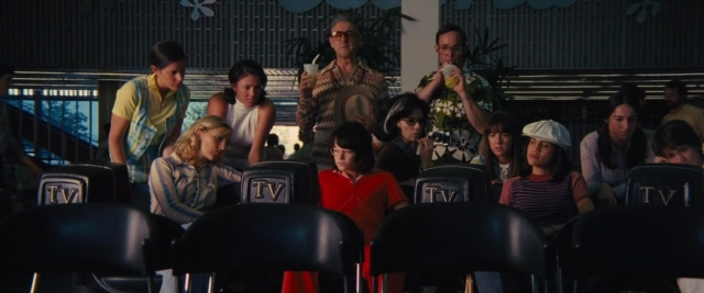 Wide shot frame from Battle of the Sexes — sitting, standing, plate