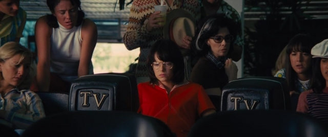 Wide shot frame from Battle of the Sexes — sitting, standing, room
