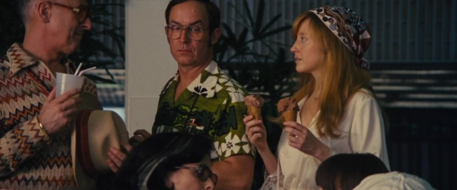 Wide shot frame from Battle of the Sexes — sitting, room, table