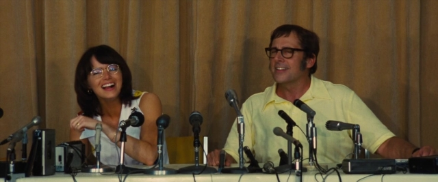 Wide shot frame from Battle of the Sexes — sitting, table, dialogue