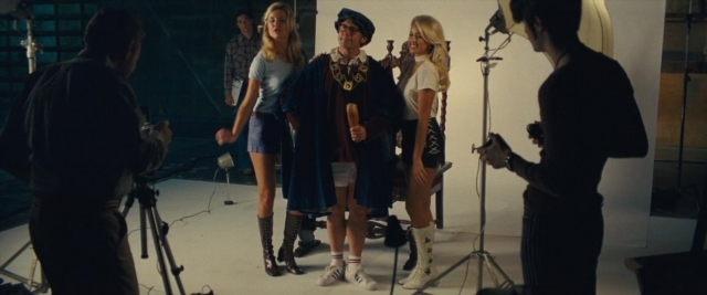 Wide shot frame from Battle of the Sexes — standing, dialogue, hat