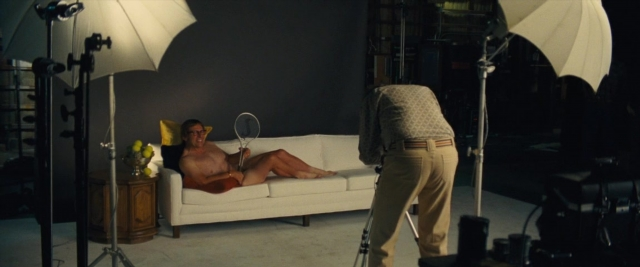 Wide shot frame from Battle of the Sexes — room, table, hand