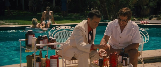 Wide shot frame from Battle of the Sexes — sitting, standing, table