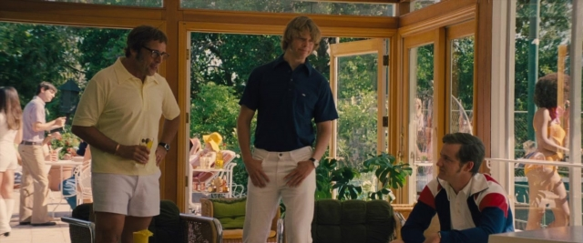 Wide shot frame from Battle of the Sexes — sitting, standing, room