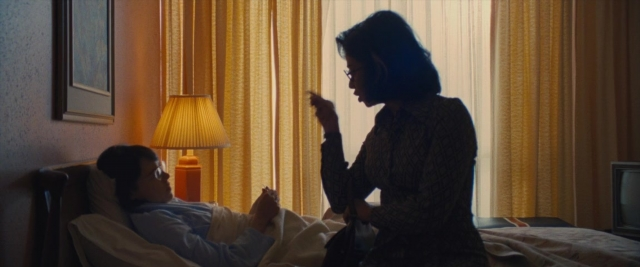 Frame from Battle of the Sexes — standing, room, bed