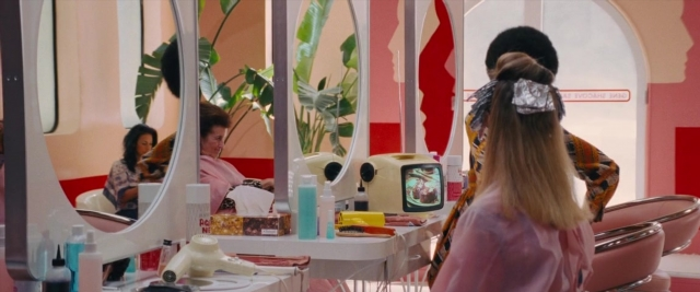 Frame from Battle of the Sexes — standing, room, table