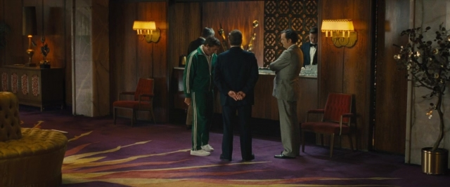 Wide shot frame from Battle of the Sexes — standing, room, dialogue