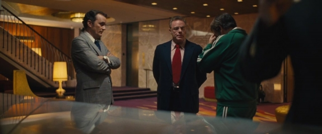 Wide shot frame from Battle of the Sexes — standing, suit, tie