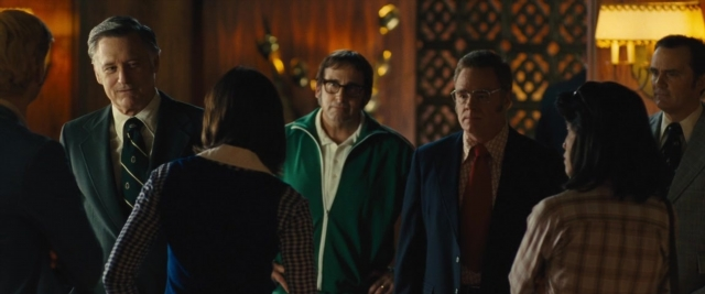 Wide shot frame from Battle of the Sexes — standing, room, suit