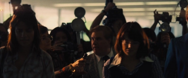 Wide shot frame from Battle of the Sexes — standing, room, dialogue