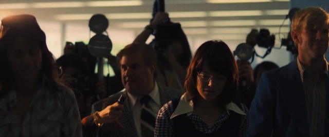 Wide shot frame from Battle of the Sexes — standing, room, dialogue