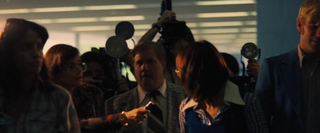 Wide shot frame from Battle of the Sexes — room, dialogue, suit