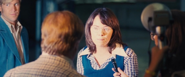 Wide shot frame from Battle of the Sexes — room, dialogue, suit