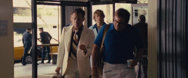 Wide shot frame from Battle of the Sexes — walking, door, hand