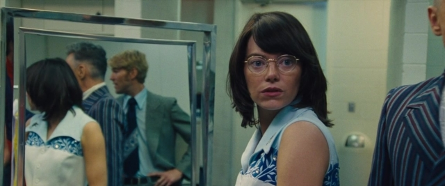 Wide shot frame from Battle of the Sexes — standing, mirror, suit
