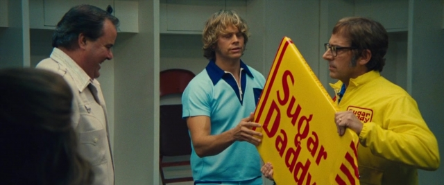 Wide shot frame from Battle of the Sexes — standing, room, dialogue