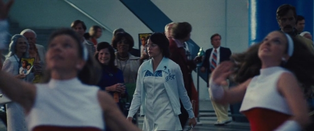 Wide shot frame from Battle of the Sexes — standing, walking, room